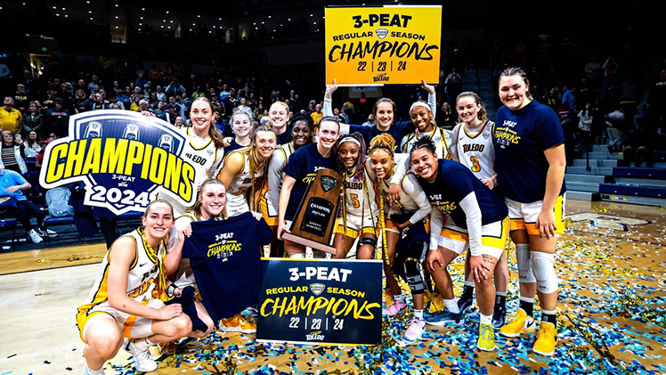 The Toledo women's basketball team poses for a team photo on the basketball court after they captured their third consecutive outright Mid-American Conference Championship with an 83-61 victory over Kent State before a joyous crowd of 6,238 at Savage Arena on Saturday.