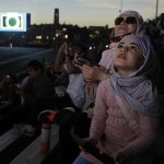Fatemeh Asnaashary and daughter, Zahra, from Dearborn, Michigan, gaze in awe at Monday afternoon’s majestic total solar eclipse, joining hundreds of eclipse watchers in Glass Bowl Stadium to share in this once-in-a-lifetime moment, totality, as the moon’s shadow shrouded Toledo in partial darkness. 