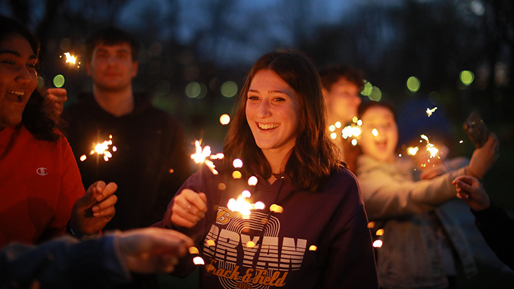 Sydnee McLennan, a marketing student, holds a sparkler during the RocketFest bonfire Friday evening at the flatlands. RocketFest delivered a week of student events and activities on Main Campus