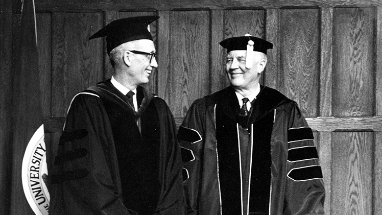 Black-and-white photo from April 19, 1968, of University of Toledo President William S. Carlson (right) and Graduate School Dean William H. Leckie wearing the proposed and traditional commencement academic garbs, respectively.