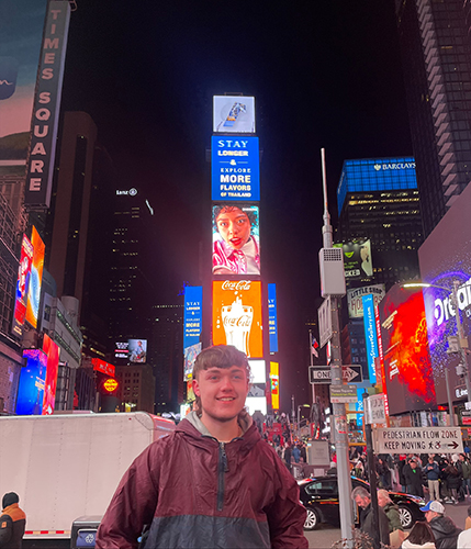 Environmental geography student Jacob Davinson poses for a photo in New York's Times Square.