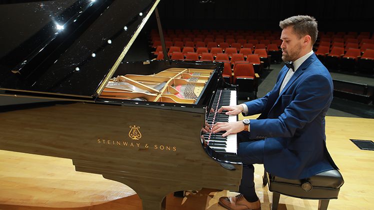 Gabriel Hagedorn, who has been playing piano since childhood and will graduate Saturday, May 4, with his master of music in performance, performs at one of UToledo's Steinway pianos.