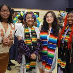 Four female UToledo students pose for a photo during the Multicultural Graduation Ceremony.