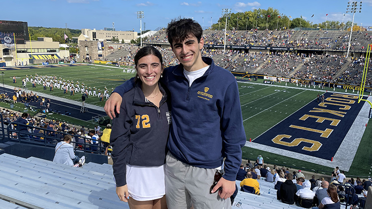 Graduating biology student Peter Tsatalis and his older sister pose for a photo at a UT football game.