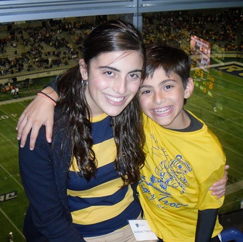 Graduating biology student Peter Tsatalis, then a small boy, and his older sister, who was then a UToledo student, pose for a photo at a UT football game in 2013.