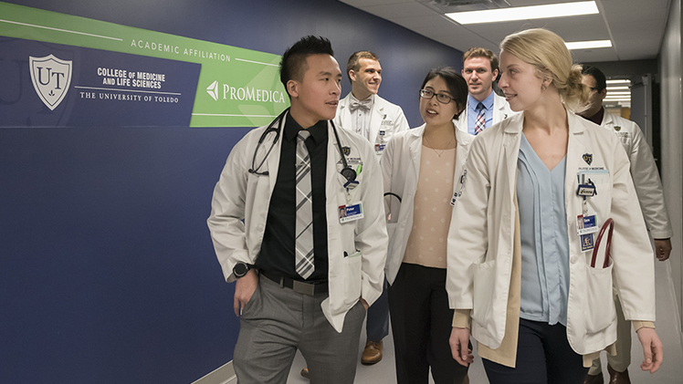 UToledo College of Medicine and Life Sciences students walk through a hall.