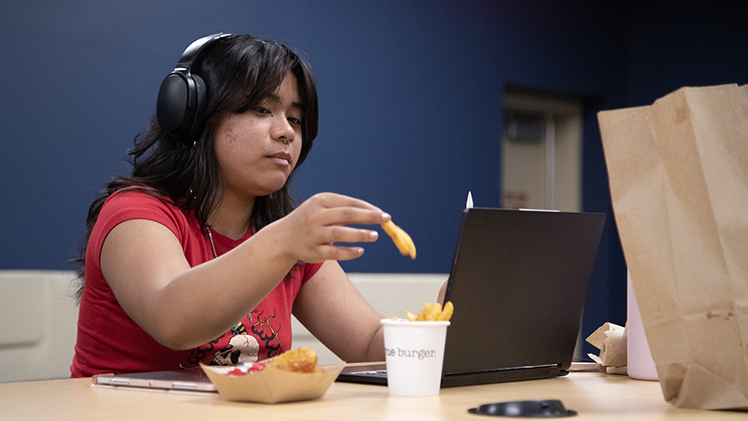 Paulo Nadal, a sophomore studying computer science and Engineering, grabs a french fry as she remotely attends an online linear algebra course last week in Thompson Student Union.