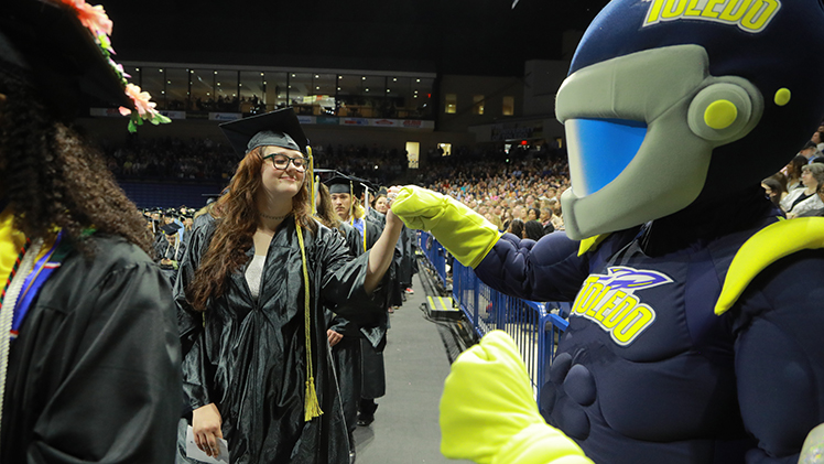 Rocky fist bumps Sophie Fisher during the second of two undergraduate spring commencement ceremonies Saturday in Savage Arena. Fisher graduated cum laude with a bachelor’s degree in university studies. 