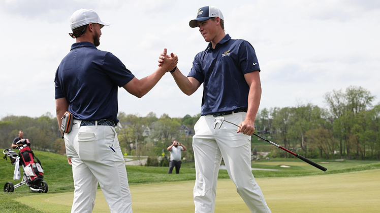 UT men's golfer Barend Botha is congratulated by a teammate on the 18th hole.