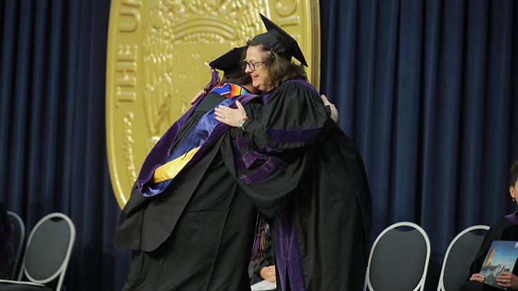 UToledo College of Law Interim Dean Rebecca Zietlow congratulates a graduate during the college's Sunday afternoon commencement ceremony in Savage Arena, during which 112 juris doctors were awarded.