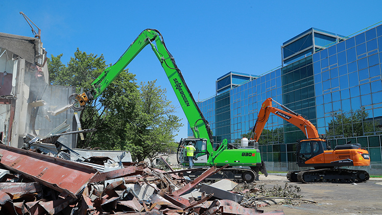 Photo of a material handler as it begins the demolition of Palmer Hall.