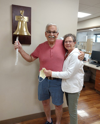 David Snyder and his wife, Pam, pose for a photo as he rings the bell at UTMC to signal that he beat cancer.