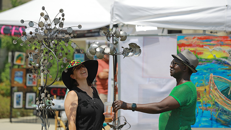 Jenyl Linkey and her husband, Yaya Cabo, from Toledo, choose one of artist Tommy Earsing’s kinetic metal sculptures during Sunday’s 31st annual Art on the Mall at Centennial Mall on Main Campus.