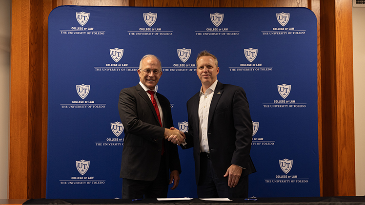 Matt Schroeder, interim president of UToledo, and Dr. Jeffrey Docking, president of Adrian College shake hands after they formalized a joint degree agreement at a press conference on Wednesday, July 24. 