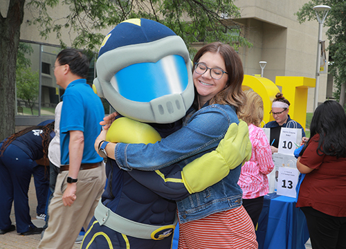 Allison Spencer, administrator of graduate programs for the College of Medicine and Life Sciences, gives Rocky a hug.