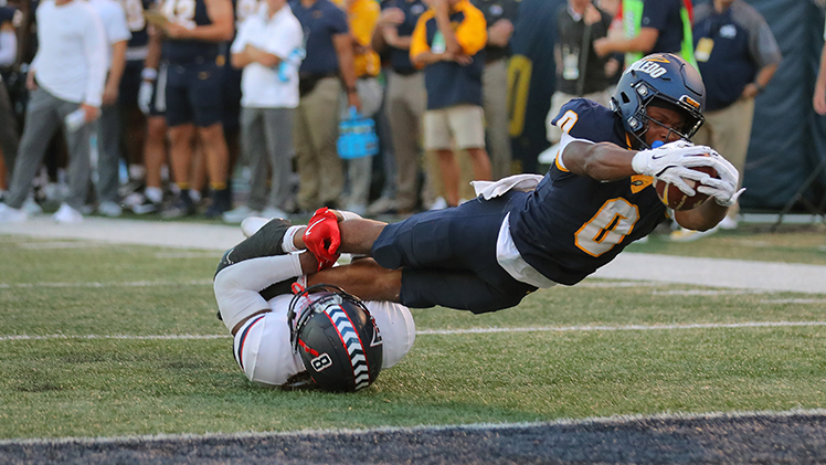 Toledo senior wide receiver Jacquez Stuart stretches into the end zone with the football as he is being tackled. 