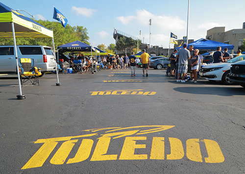 Photo of the parking lot with "Toledo" painted on the pavement leading up to Glass Bowl Stadium.