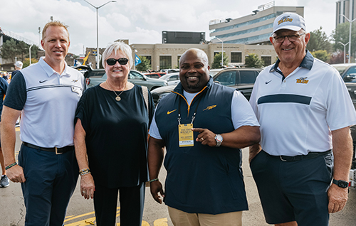 Interim President Matt Schroeder, left, and Toledo Vice President and Director of Athletics Bryan B. Blair, center right, pose with Roy and Marcia Armes, founder of the Roy and Marcia Armes Engineering Leadership Institute in the College of Engineering during pre-game festivities.