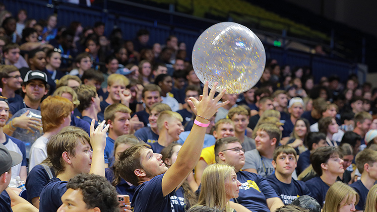 Students play with a large inflatable ball right before convocation at Savage Arena. 