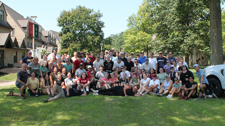 Volunteers pose for a photo outside McComas Village during a community event to beautify the grounds on Sunday, Aug. 4.