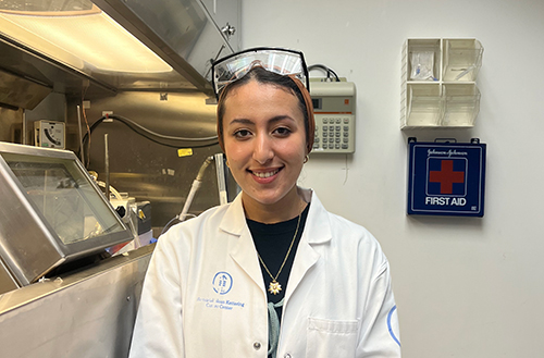 Nabaa Ali, a senior studying in biology and women’s and gender studies with a minor in chemistry, smiles for a photo while working in a research lab.