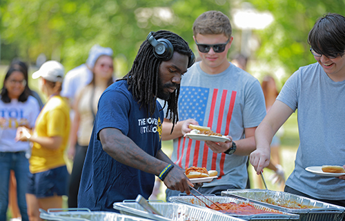 A UToledo student makes his lunch at the class of 2024 barbecue on the Flatlands.