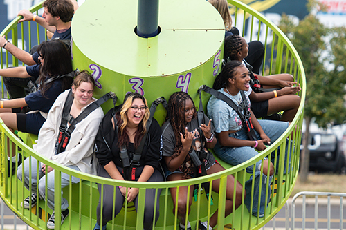 UToledo students on a spinning ride at the annual CAP Carnival at Carter Field as part of the 2024 Rocket Welcome Weekend.