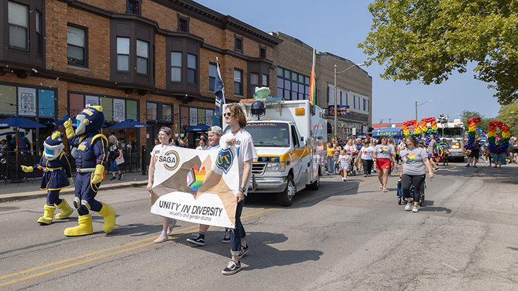 Members of The University of Toledo community walk in the Toledo Pride parade down Adams Street in downtown Toledo.