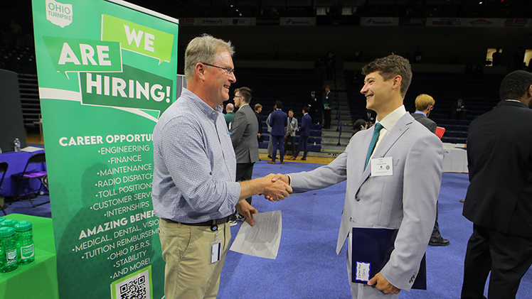 Carson Chapel, a civil engineering student, shakes hands with Douglas Ray, a west construction area engineer for the Ohio Turnpike and Infrastructure Commission, during Thursday’s Fall Engineering Career Expo in Savage Arena.