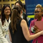 Krutika Iyer, a junior studying marketing and information systems, left, and Salome Wadesisi, a senior studying marketing, speak with a recruiter from National Corporate Housing at Thursday’s John B. and Lillian E. Neff College of Business and Innovation Fall 2024 Job Fair at Savage Arena.