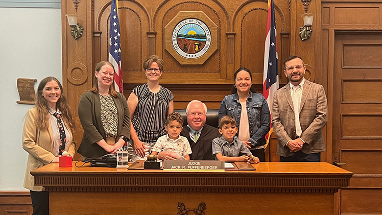 Cristina Alvarado and Amy Overmyer worked with UToledo’s Civil Advocacy Clinic so that Overmyer could adopt their two sons, Gabriel, 5, and Cristian, 3, on June 24. From left are Hailey Swartwood, Megan Anderson, Amy Overmyer, Cristian, Judge Jack Puffenberger, Gabriel, Cristina Alvarado and Rob Salem.