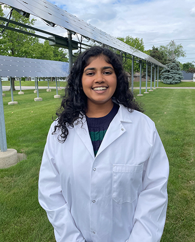 Portrait of UToledo student Samie Kumar outside in front of solar panels.