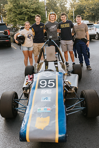 Tim Del Signore, far right, president of Rocket Motorsports, and some of the team members pose with the Formula One-style racecar they built from scratch. 