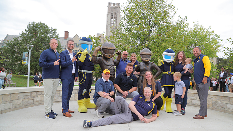 UToledo officials, former mascots and the real-life Rocky and Rocksy pose for a photo at the unveiling of the bronze statues of Rocky and Rocksy mascots in a new plaza facing the steps of Thompson Student Union.