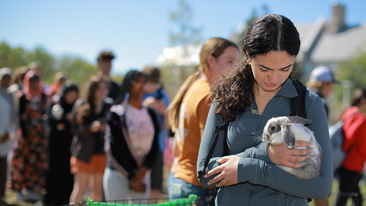 Lydia Kamel, a freshman studying health sciences, cuddles with a rabbit.