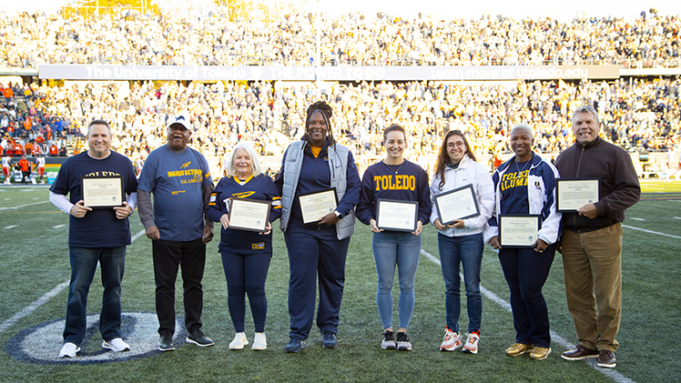 The Varsity T Hall of Fame 2024 class was introduced during halftime of Saturday’s Toledo-BGSU football game. The inductees are, from left, Ron Warga; Christopher Smith, the older brother of the late Glyn Smith, who was inducted, and Shanna Smith, widow of Glyn Smith; Yolanda Richardson Swain; Kylie Gamelier; Natalia Gaitan; Arnika Edwards Bess; and Joe Conroy.