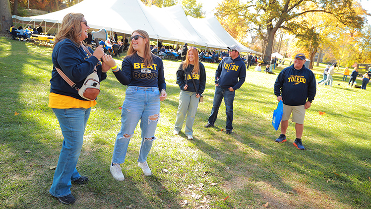 Before Saturday's Toledo-BGSU game, Emily VanHorn, a freshman studying drug discovery and design, and her mother, Nikki, laugh about axe throwing with the rest of her family, Madison Bowman, brother Ryan Fisher and her father, Tim VanHorn.