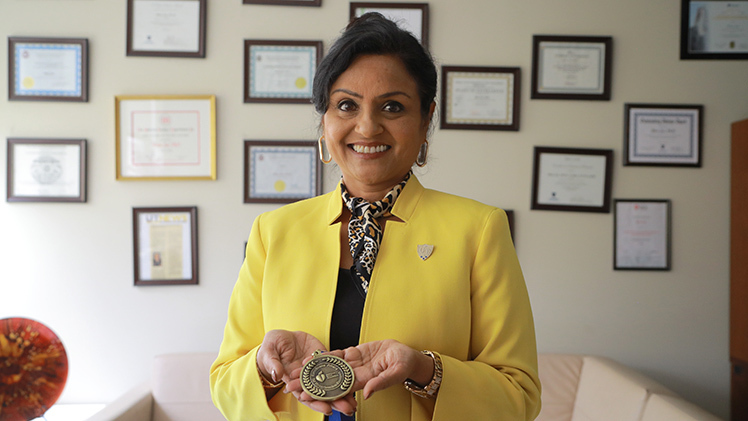 Dr. Bina Joe, a Distinguished University Professor and chair of The University of Toledo Department of Physiology and Pharmacology, holding her prestigious Excellence in Hypertension Research Award.