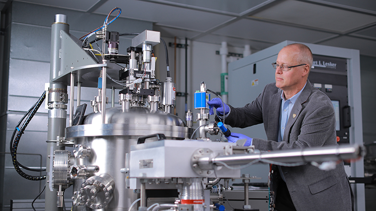 Dr. Randall Ellingson, a professor in the Department of Physics and Astronomy and Wright Center for Photovoltaics Innovation and Commercialization Endowed Chair, works on equipment in his research lab.