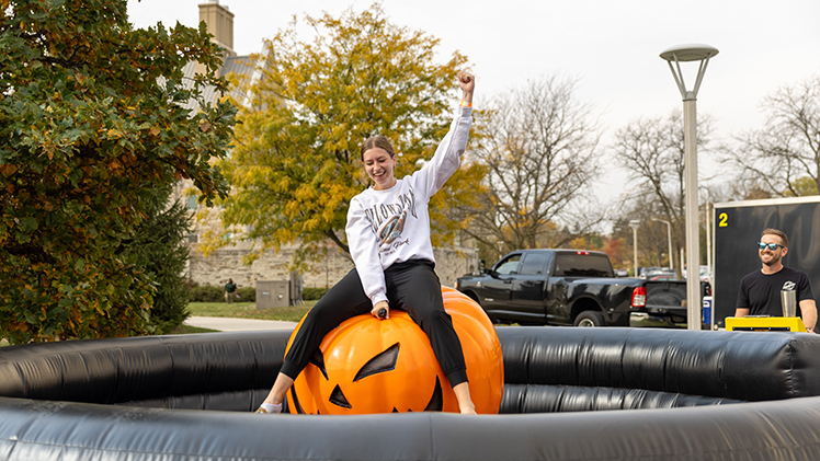 Maddy Tomaszewski, a junior studying recreational therapy, rides a mechanical jack-o'-lantern Thursday afternoon at the Campus Activities and Programming’s Fall Fest on Memorial Field House Lawn.