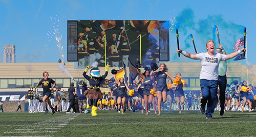 Students with sparklers, cheerleaders and Rocksy run onto the field before the football team to open the 2024 Homecoming Game. 