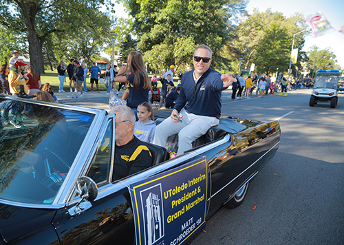 Interim President Matt Schroder as parade grand marshal rides in a car with his family.