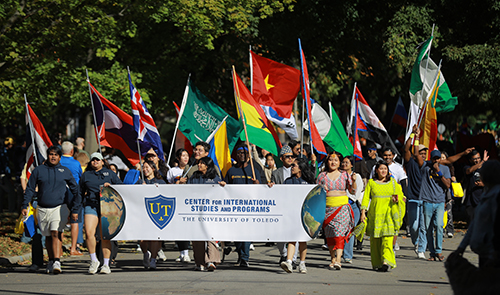 Members of the Center for International Studies and Programs were colorful clothes from their home countries as they march in the 2024 Edward C. and Helen G. Schmakel Homecoming Parade.