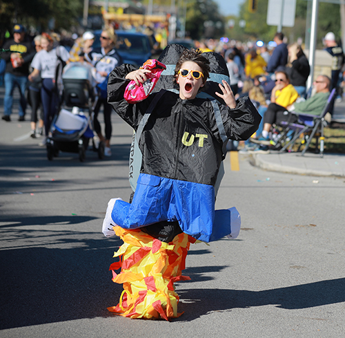 A student dressed in a rocket man jet pack walks in the 2024 Edward C. and Helen G. Schmakel Homecoming Parade.