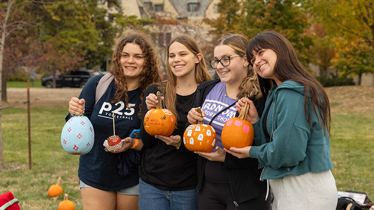 From left, Katelyn Barnhart, a freshman studying nursing, Annabell Wels, a freshman studying pharmacy, and Andrea Mckinney and Zoe DeVecka, both freshmen studying legal and paralegal studies, pose with their decorated pumpkins.