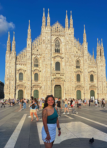 Graduating education senior Esperanza Hallauer poses in front of a large, ornate building in Europe.