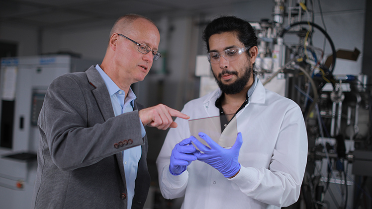 Dr. Randall Ellingson, left, a professor in the Department of Physics and Astronomy and Wright Center for Photovoltaics Innovation and Commercialization Endowed Chair, discusses materials that could be used in space-based solar technology with doctoral student Nadeesha Katakumbura. Ellingson leads a research project announced in September that will bring up to $15 million to UToledo.