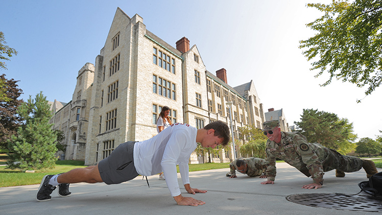 Staff Sgt. Dustin McGee, right, with Ohio Air National Guard’s 180th Fighter Wing smiles as he watches Aaron Smith, a junior studying exercise science, complete 22 pushups at the sixth annual 22 Pushup Challenge in September.