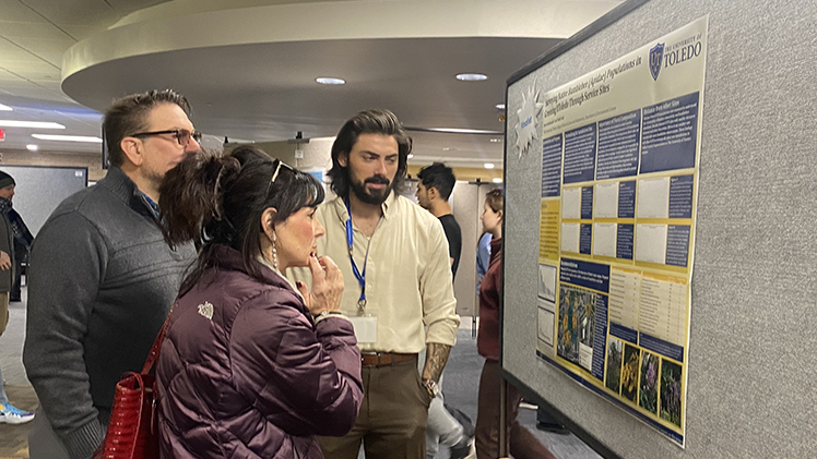 Brock Hochanadel, a senior studying environmental sciences, discusses his research poster with his parents, Steve and Danielle Hochanadel, last month during the Office of Undergraduate Research’s Undergraduate Research and Creative Activity Exhibition at Carlson Library.