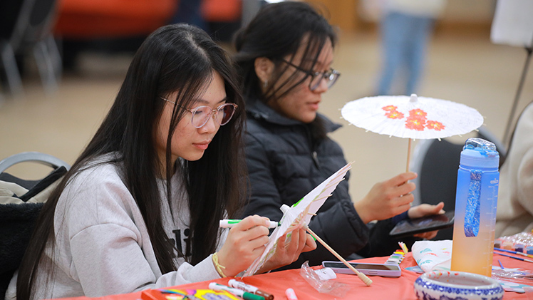 Nhi Nguyen, a left, a sophomore in the College of Engineering, and  Samenta Thapa, a sophomore in the John B. and Lillian E. Neff College of Business and Innovation, each design a craft at Thursday’s Spring Festival Carnival in Thompson Student Union Auditorium.